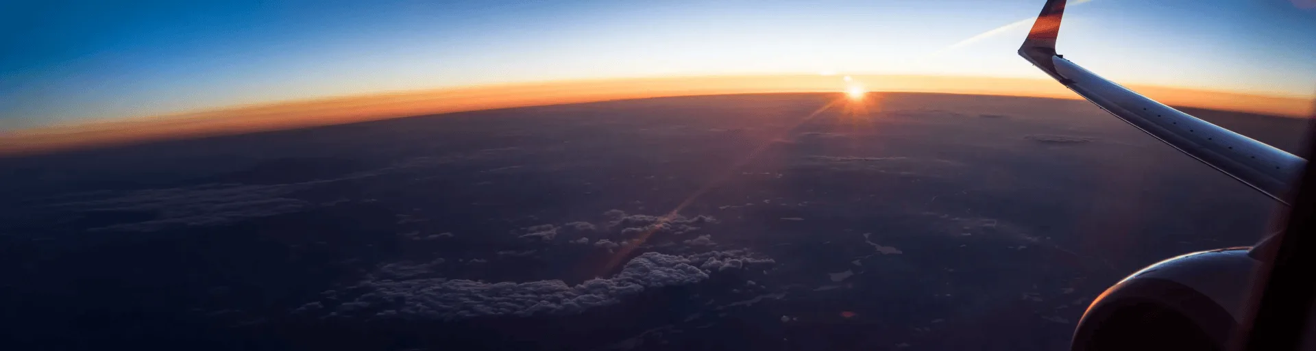 Airplane wing over a sunset